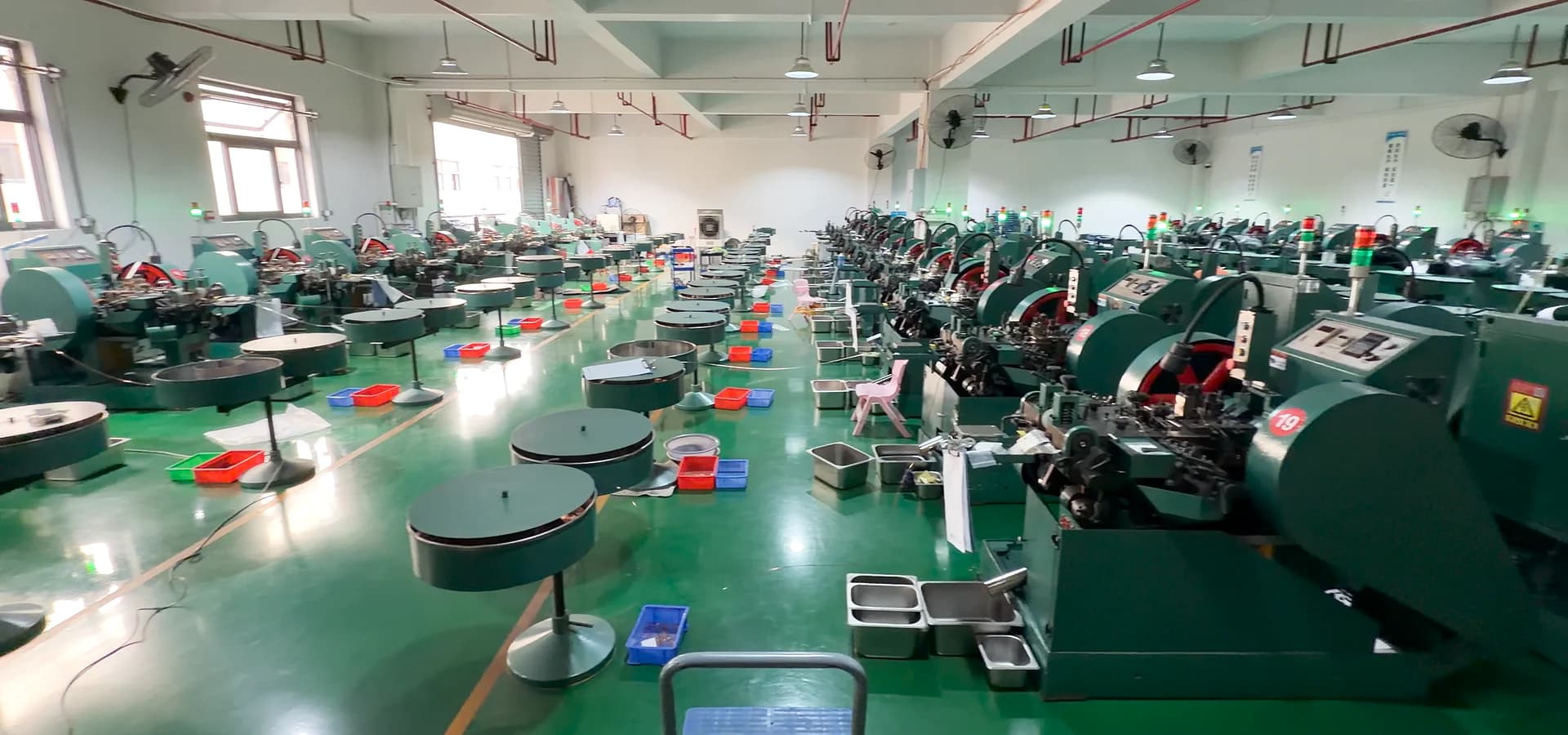 Electrical contact production workshop with manufacturing equipment arranged across the floor.