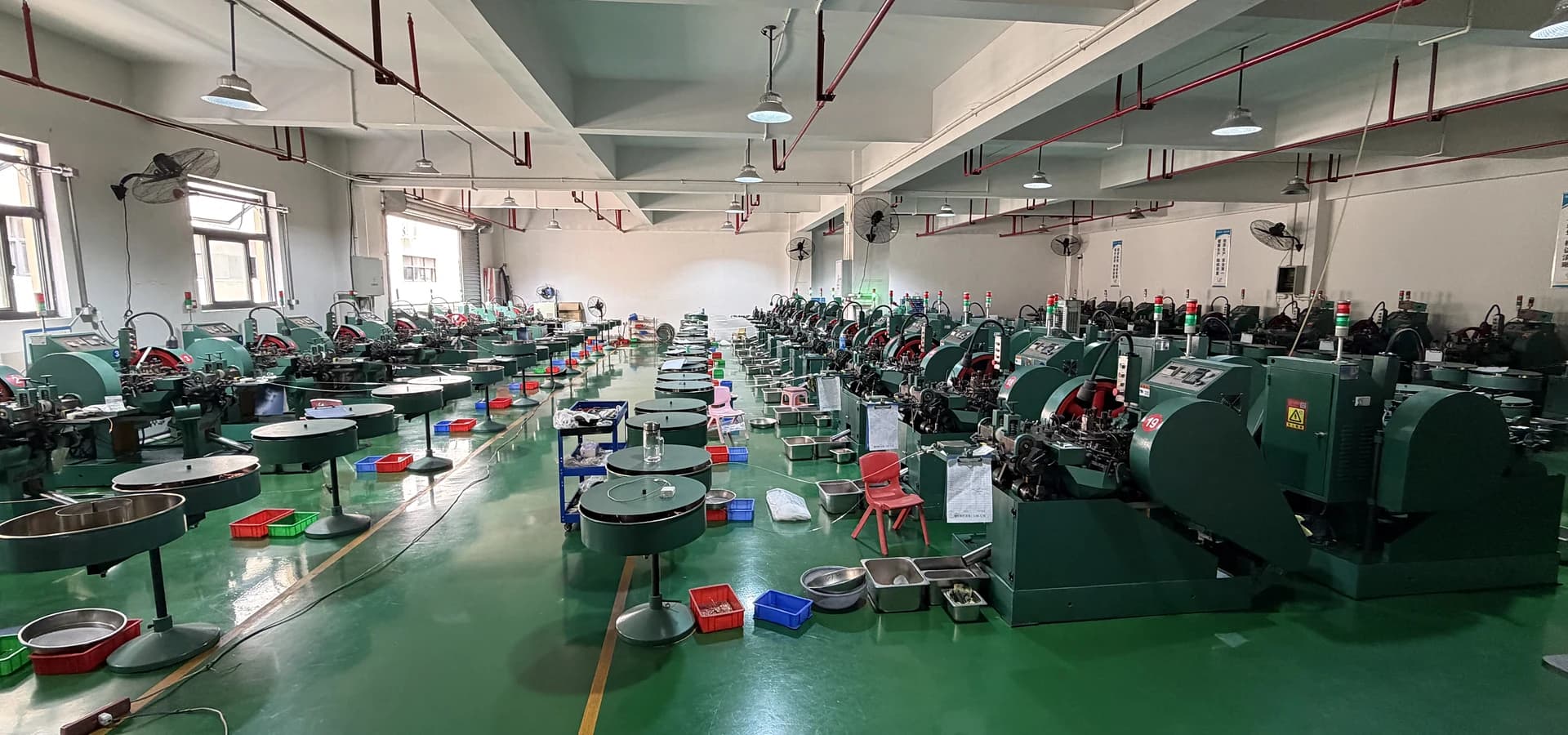 A photographed manufacturing floor with forming equipment and material-handling stations.